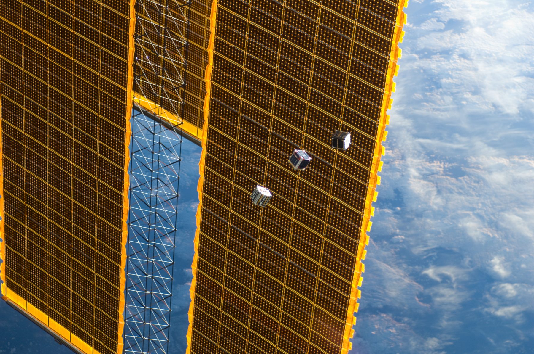 Satellites beside the space station solar array